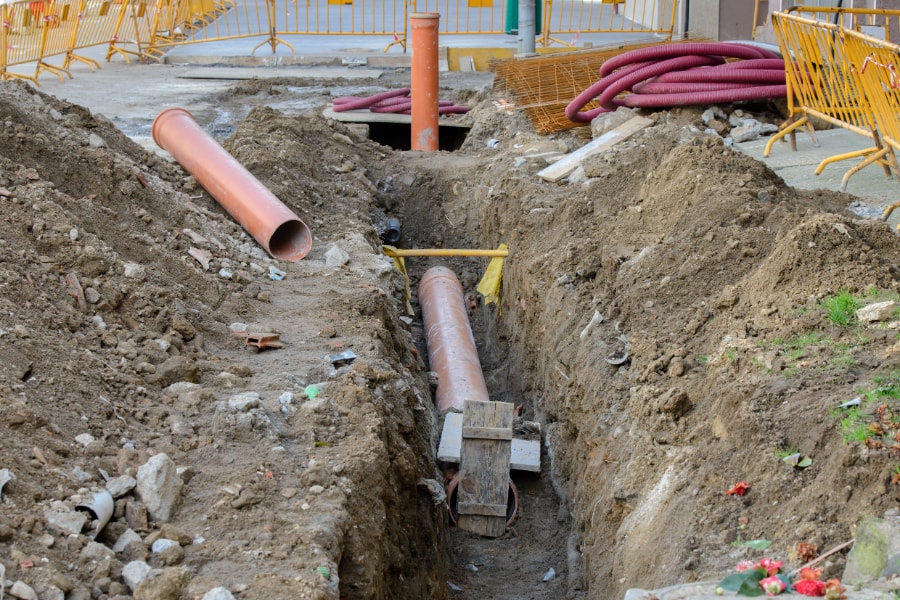 Plastic surface water drainage pipes being layed in channel in readiness to be connected