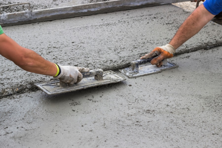 Our specialist concrete contractor levelling newly poured concrete on driveway.